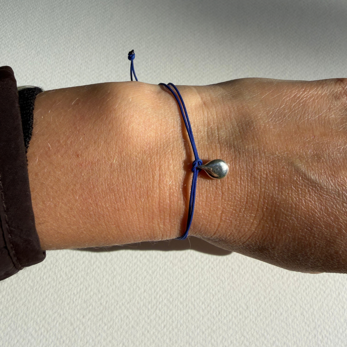 Gyllen dråpe armbånd, blå nylonsnor med sølv dråpe